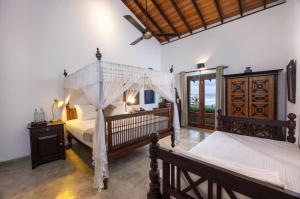 a bedroom with two beds and a ceiling fan at Villa Atulya at Ocean's edge in Mirissa +58 photos