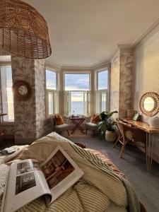 a bedroom with a bed with a book on it at Môr Heli Guest House Criccieth in Criccieth +50 photos