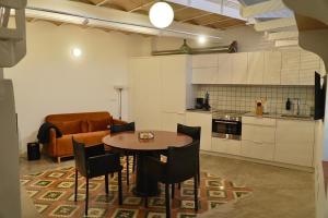 a kitchen with a table and chairs and a couch at A Bolota, Casa rural in Trevejo
