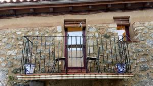 a balcony on a stone building with a window at A Bolota, Casa rural in Trevejo