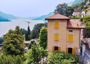 a house on a hill next to a body of water at Villa Eugenia - Suite Iris in Carate Urio