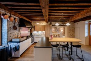 a kitchen with a wooden table and a wooden ceiling at Sur Les Roches in Dracy-lès-Couches