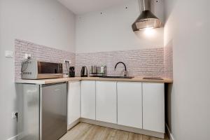 a kitchen with white cabinets and a microwave at Central Platinum Apartments 19 in Rybnik