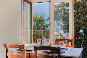 a dining room with a table and chairs and windows at Villa Eugenia - Suite Iris in Carate Urio