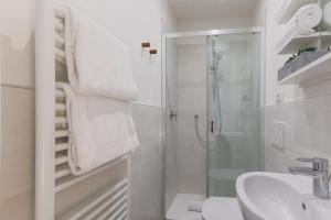 a white bathroom with a shower and a sink at Villa Eugenia - Suite Iris in Carate Urio +13 photos