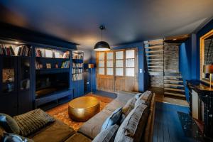 a blue living room with a couch and a table at Sur Les Roches in Dracy-lès-Couches