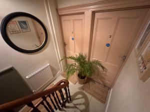 a hallway with a mirror and a wooden bench at Môr Heli Guest House Criccieth in Criccieth