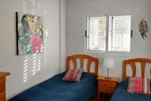 a bedroom with two beds and a window at SOLMAR La Mata Beach in Torrevieja