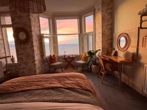 a bedroom with a bed and a view of the ocean at Môr Heli Guest House Criccieth in Criccieth