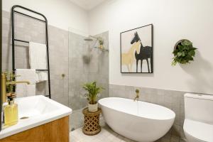 a bathroom with a white tub and a sink at Am Flus- at the river in Stellenbosch