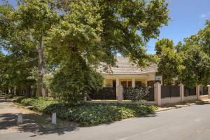 a house with a fence and a tree at Am Flus- at the river in Stellenbosch