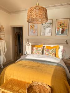 a bedroom with a large bed with a yellow blanket at Môr Heli Guest House Criccieth in Criccieth