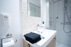 a white bathroom with a sink and a shower at Charming Elegant Suite - Downtown - AF in Carcassonne
