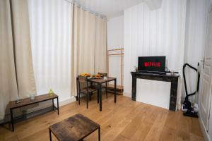 a living room with two tables and a television at Charming Elegant Suite - Downtown - AF in Carcassonne