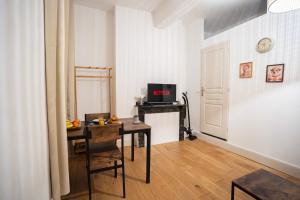a room with a desk and a table with a television at Charming Elegant Suite - Downtown - AF in Carcassonne
