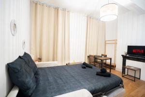 a bedroom with a black bed and a piano at Charming Elegant Suite - Downtown - AF in Carcassonne