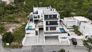 an aerial view of a white house with a waterfall at Luxurious Sea-View 2BR Apartment with Private Pool-Villa Quadris-Crikvenica in Crikvenica