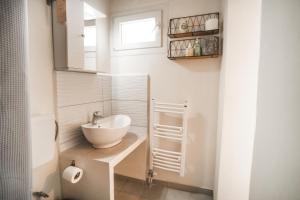 a bathroom with a sink and a toilet and a window at SeaSuites Artemida in Artemida +21 photos
