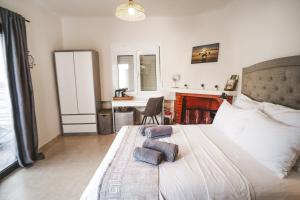 a bedroom with a bed and a desk in it at SeaSuites Artemida in Artemida