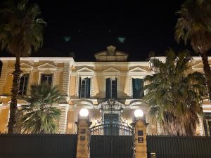 a white building with palm trees in front of it at Ciné Room Home Cinema Netflix Experience in Lunel