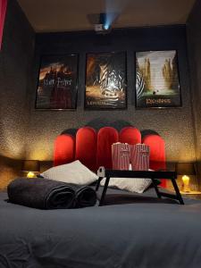 a room with a bed with red chairs and posters at Ciné Room Home Cinema Netflix Experience in Lunel