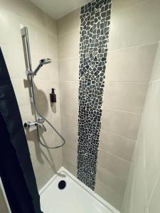 a bathroom with a shower and a bathtub with a tile shower at Ciné Room Home Cinema Netflix Experience in Lunel