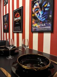 a table with two glasses and a plate of food at Ciné Room Home Cinema Netflix Experience in Lunel