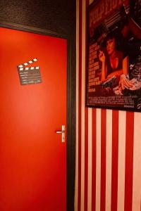 a red door with a movie poster on a wall at Ciné Room Home Cinema Netflix Experience in Lunel +11 photos