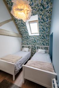 two beds in a room with floral wallpaper at Sur Les Roches in Dracy-lès-Couches +33 photos