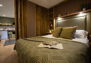 a bedroom with a bed with a book on it at City to Country Retreat Luxury Lodges with Hot Tub, BBQ, Fire Pit in Toppesfield