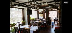 a dining room with tables and chairs and windows at Златоград in Zlatograd