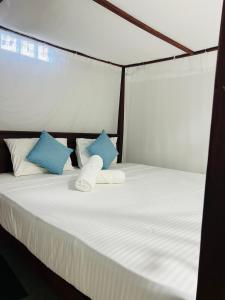 a bed with blue and white pillows at Lagoon Home Stay in Ahangama