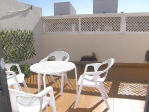 サラゴサにあるÁtico con terraza en la Jotaのパティオ(白いテーブル、椅子付)