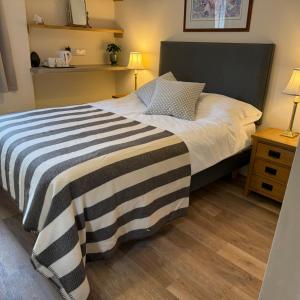 a bedroom with a bed with a black and white striped blanket at Town Centre - 22 Billet Street in Taunton