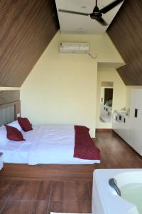 a bedroom with a bed with white sheets and red pillows at Idukki Nook in Idukki