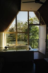 a bath tub in a room with a large window at Idukki Nook in Idukki