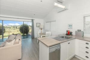a kitchen and living room with a couch and a table at Hideaway Cottage, Tauranga, so close to Bethlehem & Mount Maunganui in Tauranga