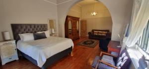 a bedroom with a bed and a living room at 14th on West in Graaff-Reinet