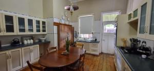 a kitchen with a wooden table and a wooden floor at 14th on West in Graaff-Reinet
