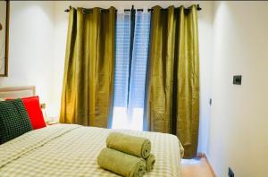 a bedroom with a bed with yellow curtains at Les princesses studio confort-plus charme in Maarif