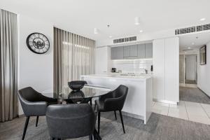 a kitchen and dining room with a glass table and chairs at Urban Oasis City 2 Bed Apartment Oaks Horizons in Adelaide