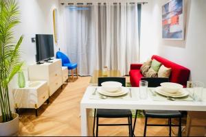 a living room with a white table and a red couch at Les princesses studio confort-plus charme in Maarif
