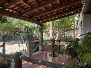 a patio with a table and chairs under a wooden pergola at Casa granero 2 in El Río