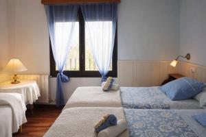 two beds in a room with a window at Apartament amb llar de foc - Golfes Cal Gravat in Montsonis +36 photos