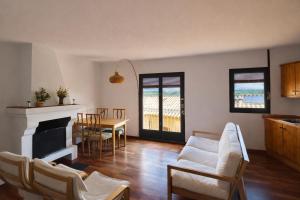 a living room with white furniture and a table at Apartament amb llar de foc - Golfes Cal Gravat in Montsonis