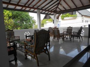 eine Gruppe von Stühlen und Tischen auf einer Veranda in der Unterkunft Shanith Guesthouse Negombo in Negombo