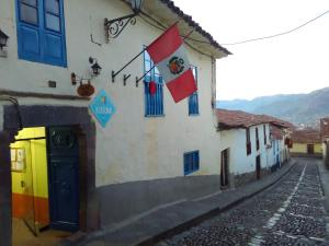 una calle con banderas al lado de un edificio en Kurumi Hostel, en Cusco