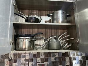 a kitchen with pots and pans on a shelf at llc APARTMENT in Kumasi