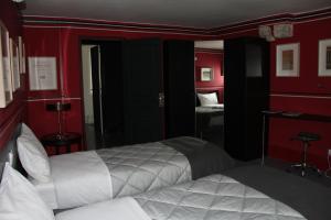 a bedroom with two beds and red walls at Blois La Tour 1696 in Blois