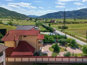 a house with a red roof and a road at Casa de vacanță in Călimăneşti +4 photos